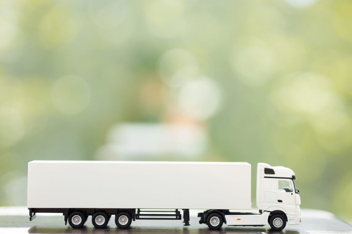 logistics-concept-truck-green-summer-background-scaled.jpg